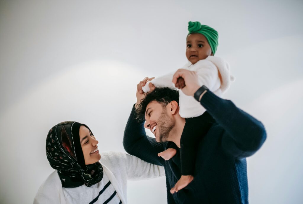 Happy family moment with parents and baby indoors, showcasing love and unity.